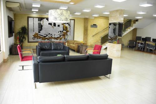 a living room with two couches and red chairs at Larison Executive by Easy Hotéis in Porto Velho