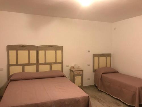 a bedroom with two beds and a nightstand at B&B Ad un passo dal Cielo in Pietrasecca