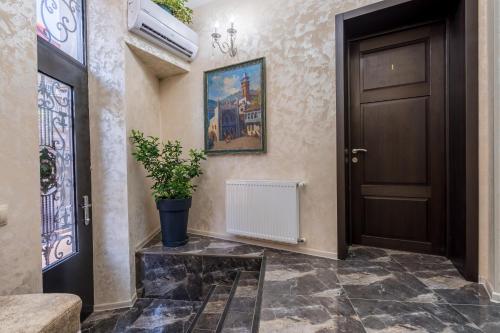 a hallway with a door and a potted plant at Golden Light Hotel in Tbilisi City