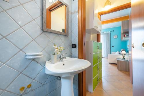 W łazience znajduje się umywalka i lustro. w obiekcie Lovely Apartment near the Sea - WiFi & Air Con w mieście Santa Luria
