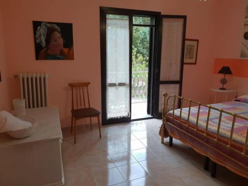 a bedroom with a bed and a table and a window at La Casa Del Mosileo in Vietri di Potenza