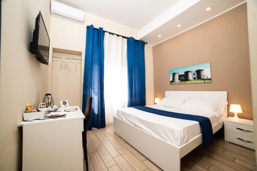 ナポリにあるB＆B メトロポリタンのベッドルーム(白いベッド、青いカーテン付)