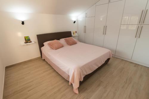 1 dormitorio con 1 cama y armarios blancos en Honey Farm House en Virpazar