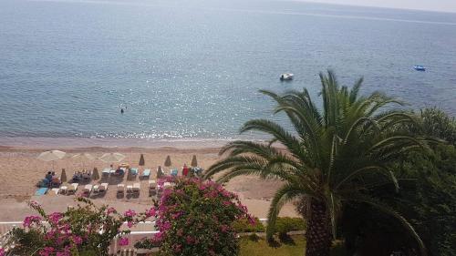 a beach with chairs and umbrellas and the ocean at Ilaira Apartments in Khránoi