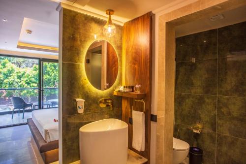 a bathroom with a toilet and a shower and a mirror at Orka Sunlife Resort Hotel and Aquapark in Oludeniz