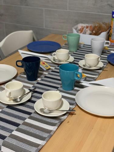 een tafel met borden en bekers en schotels erop bij B&B La Corte in Santa Maria Capua Vetere