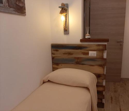 a small bedroom with a bed with a wooden headboard at B&B Ad un passo dal Cielo in Pietrasecca