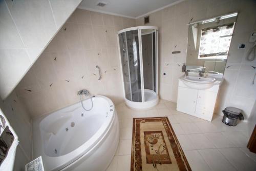 a bathroom with a tub and a toilet and a sink at Hotel & Spa Arkadia in Tomaszów Lubelski