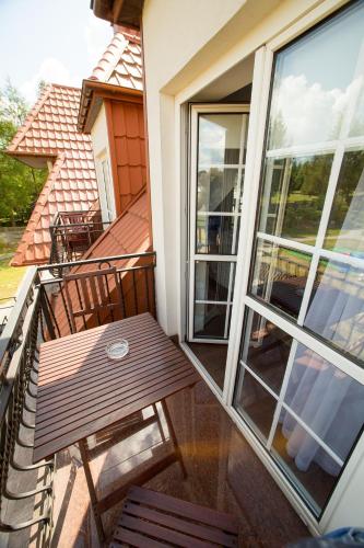 a wooden bench on the balcony of a house at Hotel & Spa Arkadia in Tomaszów Lubelski