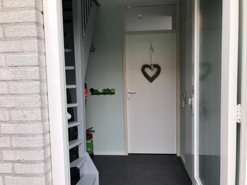 a white door with a heart on the wall at Paleisje Noordwijk in Noordwijk