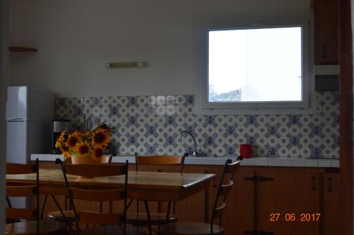 une cuisine avec une table et des chaises et une fenêtre dans l'établissement Maison de vacances, à Saint-Sulpice-de-Royan