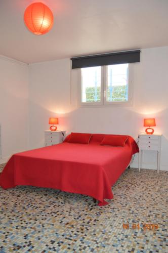 - un lit rouge dans une chambre blanche avec deux lampes dans l'établissement Maison de vacances, à Saint-Sulpice-de-Royan
