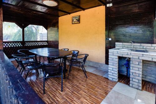 a dining room with a table and chairs and a fireplace at Vila Pabo in Vama Veche