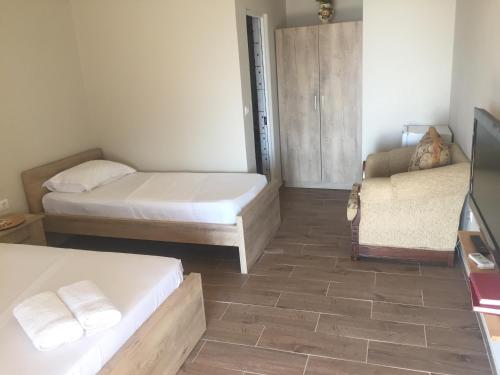a small bedroom with two beds and a couch at Xuxi Apartments in Lukovë