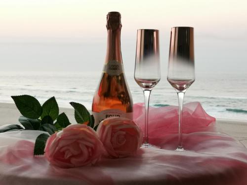 a bottle of champagne and two glasses on a beach at Boulevard 501 in Margate