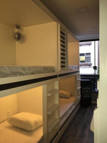 um quarto beliche com 2 camas e uma janela em AIPA HOSTEL.COM em Cabo Frio