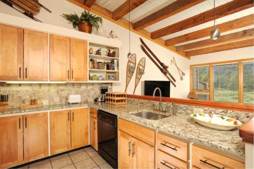 a large kitchen with wooden cabinets and a sink at Evergreen Condominiums by Keystone Resort in Keystone