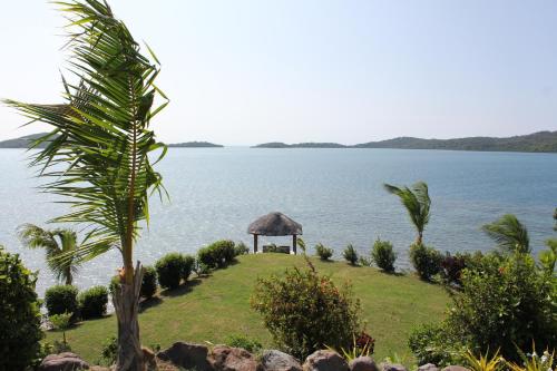 a gazebo on a lawn next to the water at Bularangi Villa, Fiji in Rakiraki