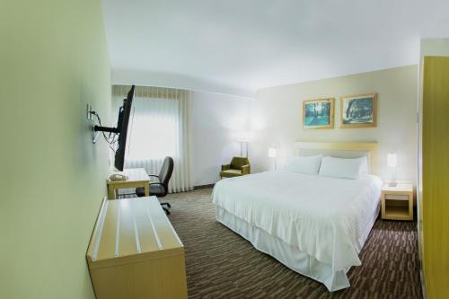 Un pat sau paturi într-o cameră la Excellence Express & Suites