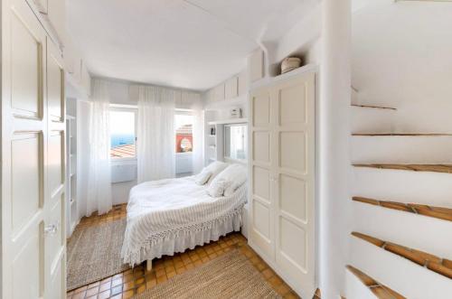 a white room with a bed and a window at Ciel d´Azur in Roquebrune-Cap-Martin