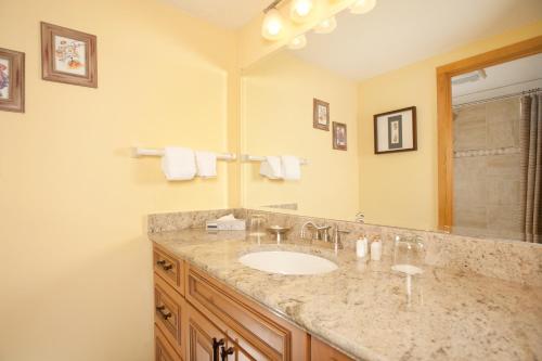 a bathroom with a sink and a large mirror at Evergreen Condominiums by Keystone Resort in Keystone