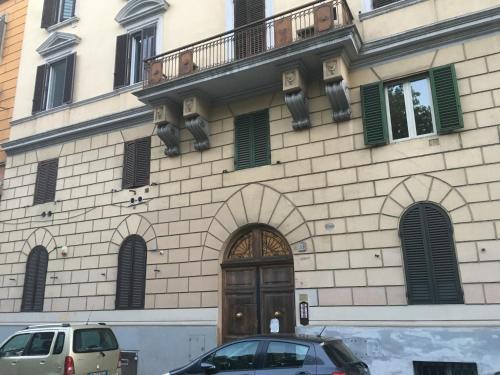 deux voitures garées devant un bâtiment avec une porte dans l'établissement All You Need is Rome Guesthouse, à Rome