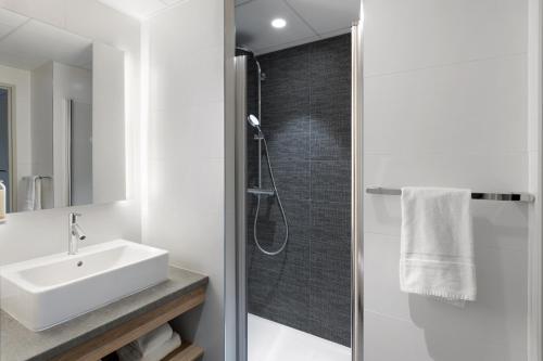 a white bathroom with a sink and a shower at BEST WESTERN HOTEL DIJON QUETIGNY in Quétigny