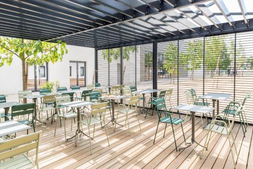 a restaurant with tables and chairs and windows at BEST WESTERN HOTEL DIJON QUETIGNY in Quétigny