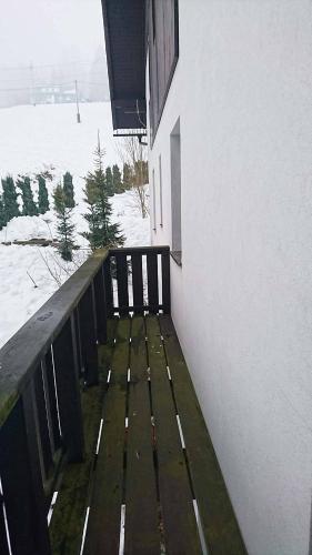a wooden bench sitting on the side of a building at Apartmány EDDY in Rokytnice nad Jizerou