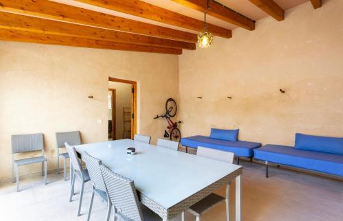 une salle à manger avec une table blanche et des chaises bleues dans l'établissement ALMAHOME, à El Arenal