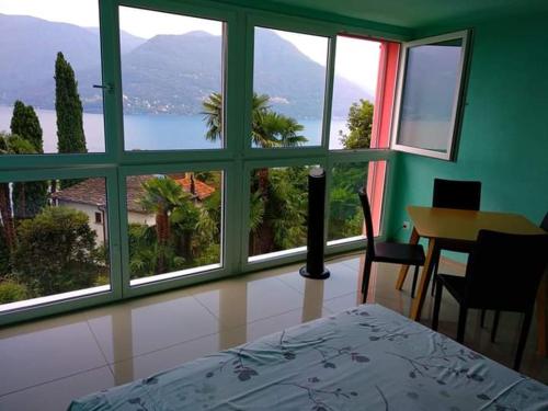 a bedroom with a large window with a view of the ocean at Residence Venus Garden in Brissago