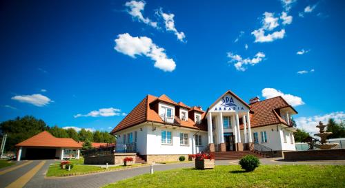a large white house with a red roof at Hotel & Spa Arkadia in Tomaszów Lubelski