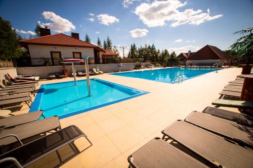 a swimming pool with chaise lounge chairs next to it at Hotel & Spa Arkadia in Tomasz&oacute;w Lubelski