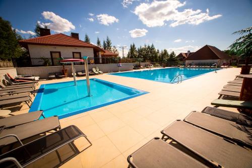uma piscina com espreguiçadeiras ao lado em Hotel & Spa Arkadia em Tomaszów Lubelski