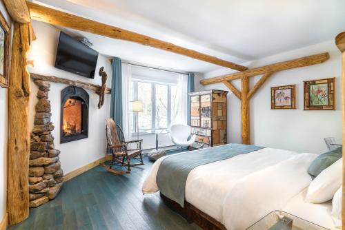 a bedroom with a bed and a fireplace at Le Baluchon Éco-villégiature in Saint-Paulin