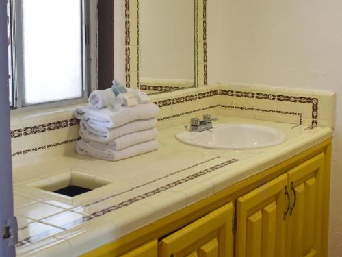 a bathroom with a sink and a mirror and towels at Castillos Del Mar in Rosarito