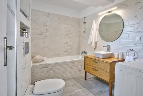 une salle de bains avec lavabo, baignoire et toilettes dans l'établissement Villa Akrochori, à Koskinou