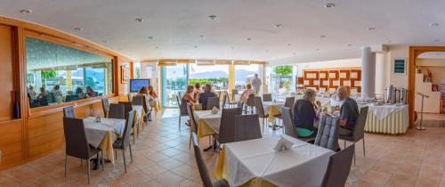 a restaurant with people sitting at tables in a restaurant at Faedra Beach in Agios Nikolaos