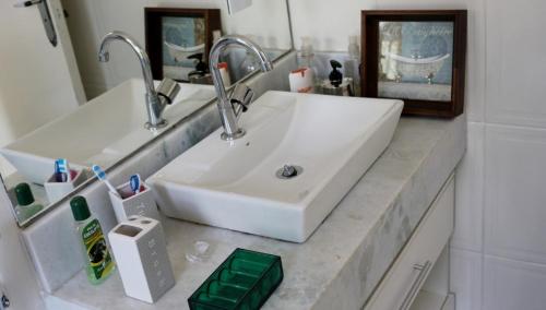 a bathroom with a white sink and a mirror at CASA DE CAMPO NA CIDADE DA SAÚDE in Serra Negra