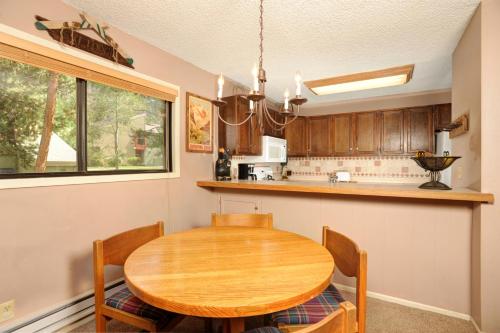 a dining room with a wooden table and a kitchen at The Forest Neighborhood by Keystone Resort in Keystone