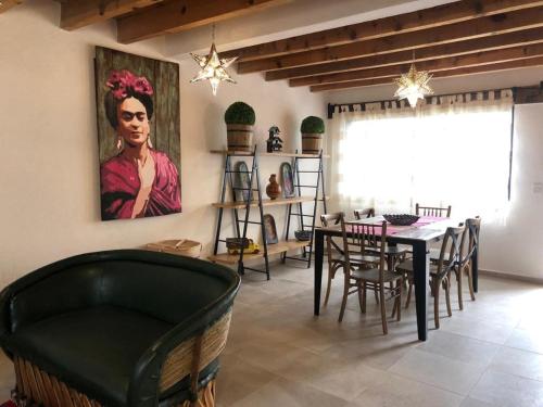 a dining room with a table and a painting on the wall at CASA FRIDA, Casa p/6 pax Centro Tequisquiapan in Tequisquiapan