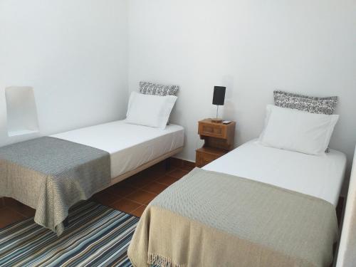 Santo AmadorにあるCasas do Ardilaのベッド2台とナイトスタンド付きの部屋