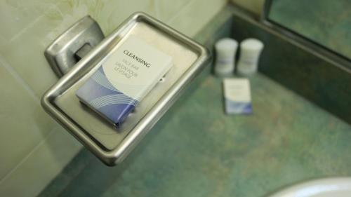 a packet of toothpaste in a metal holder in a bathroom at Elite Hotel -Downtown Center- "Ski & Northern light Tour" "Hot Spring Tour "Long-term stay" in Whitehorse