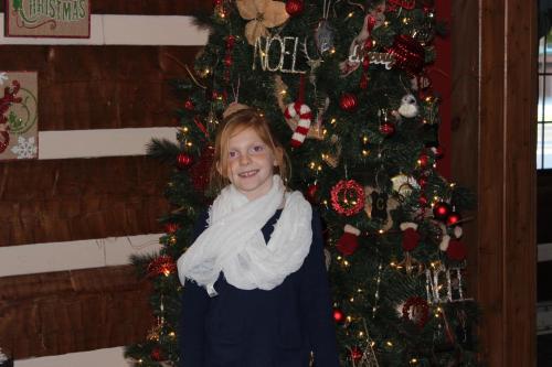 a little girl standing in front of a christmas tree at Great Smokies Inn - Cherokee in Cherokee
