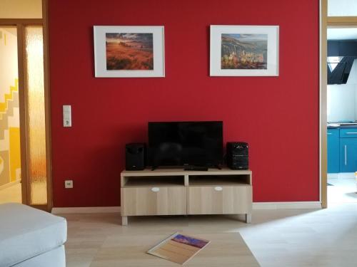 皮爾納的住宿－Ferienwohnung Angelo，一间带电视和红色墙壁的客厅