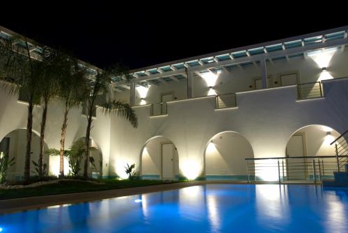een gebouw met een zwembad in de nacht bij Ganimede Hotel in Sperlonga