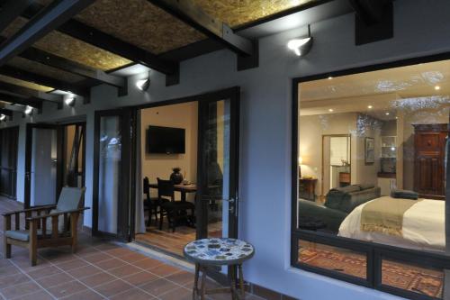a bedroom with a bed and a dining room at Kestell Stables in Bloemfontein