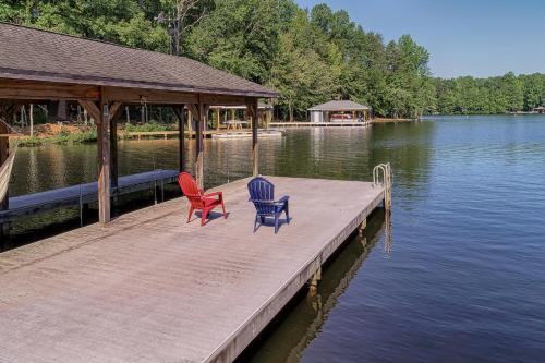 two chairs and a table on a dock on a lake at Sunset Cove in Bumpass
