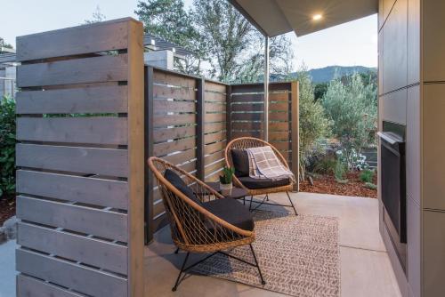 a patio with two chairs and a fence at Olea Hotel in Glen Ellen