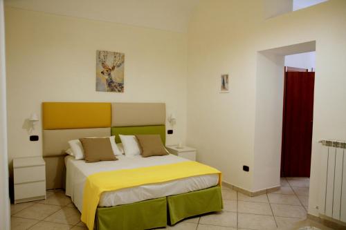 a bedroom with a large bed with a yellow blanket at Giulia's house apartments in SantʼAntonio Abate